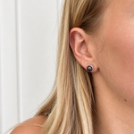 8mm black pearl stud earring in sterling silver bezel worn on ear