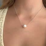 White pearl necklace with delicate sterling silver chain and single round south sea pearl, modelled on a woman. Lush Designs Jewellery Australia.