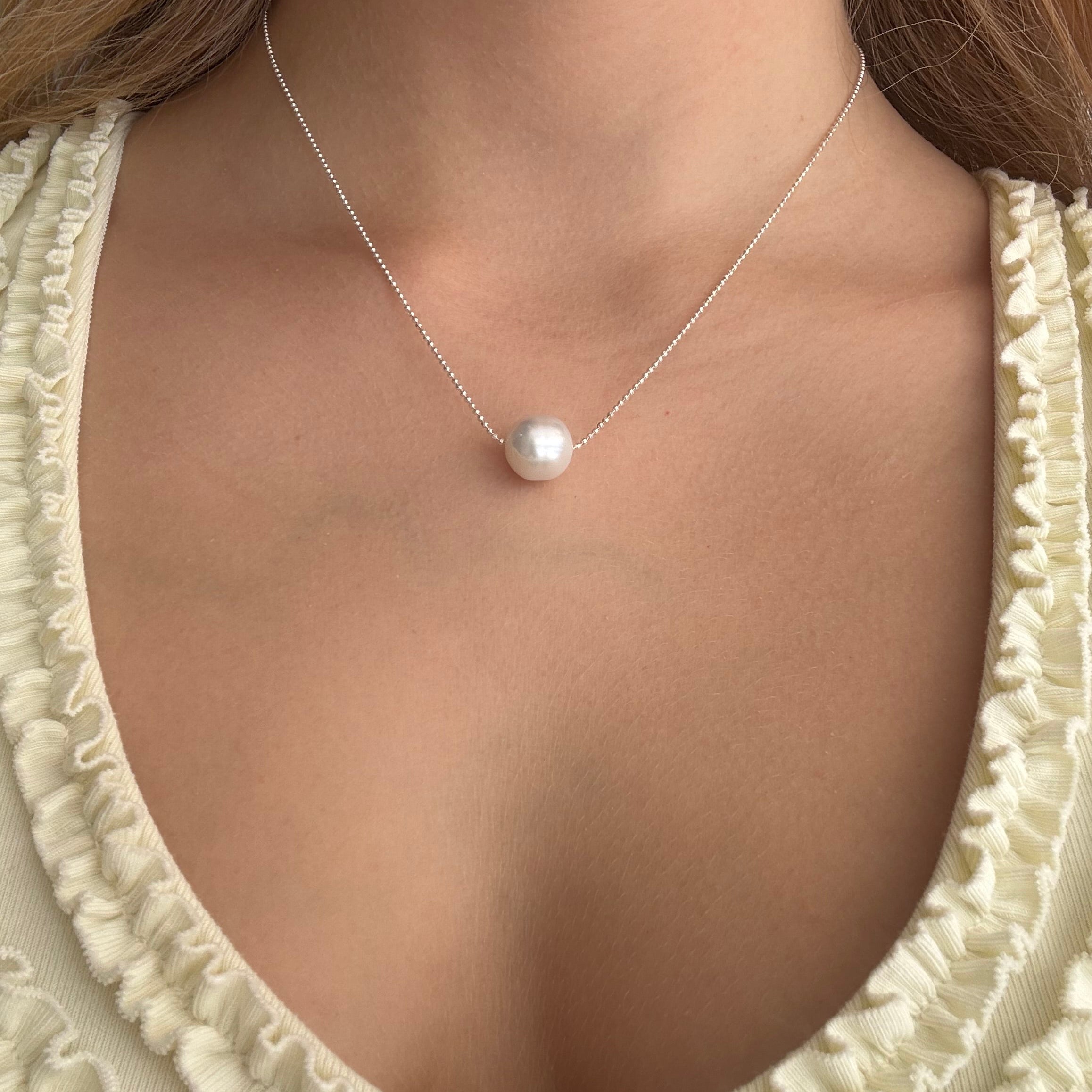 White pearl necklace with delicate sterling silver chain and single round south sea pearl, modelled on a woman. Lush Designs Jewellery Australia.