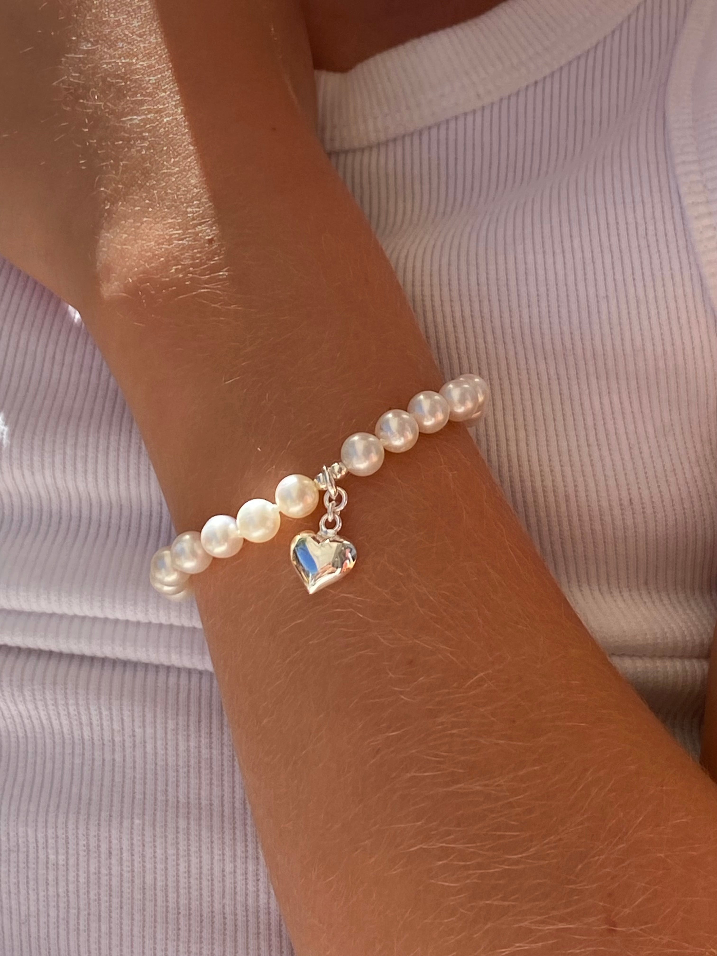 children’s pearl bracelet with silver heart charm 