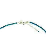 Blue beaded necklace with silver clasp on a white background