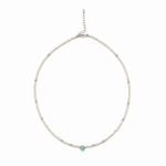 A delicate silver beaded choker necklace with a single small round turquoise gemstone at the front center, displayed on a clean white background.