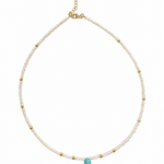 Delicate white pearl beaded necklace with gold spacer beads and a small turquoise teardrop pendant 