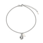 A silver chain anklet featuring a cowrie shell shaped silver pendant with a textured centre, accented by one small white pearl, shown on a plain white background.
