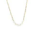 A gold chain necklace with five white pearls placed along the length, presented against a white background.