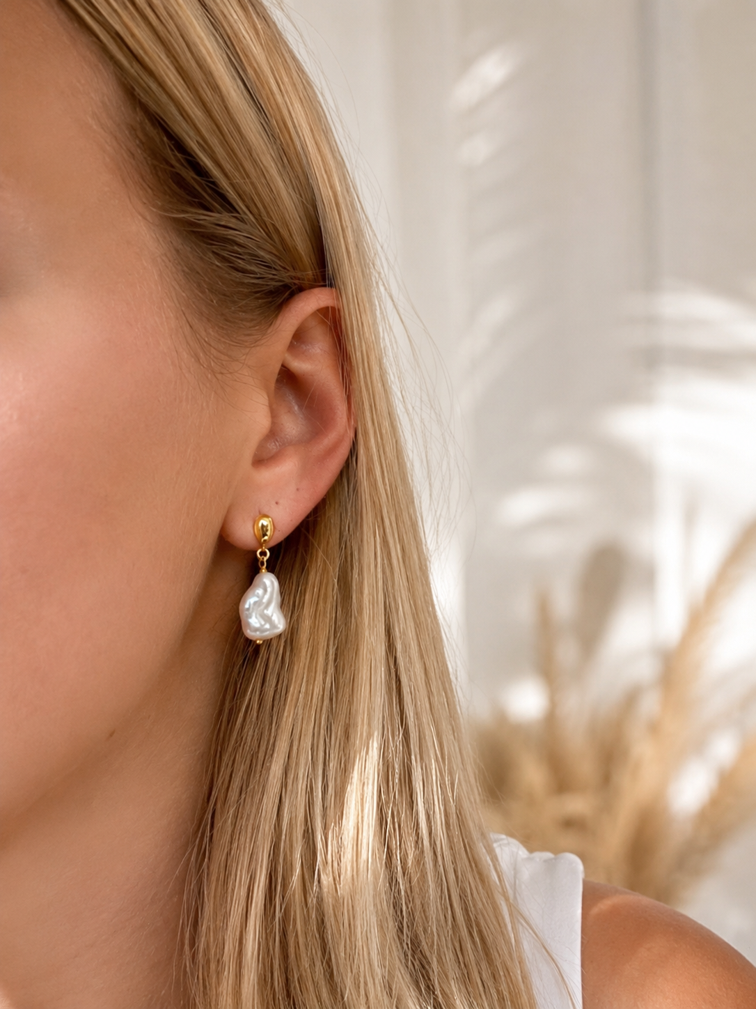 Model wearing Coastal Dew Drop 12mm baroque pearl stud earrings in gold vermeil by Lush Designs Jewellery
