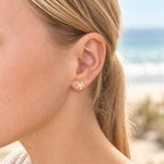 Model wearing Dainty Frangipani Pearl Stud Earrings in gold vermeil and freshwater pearl