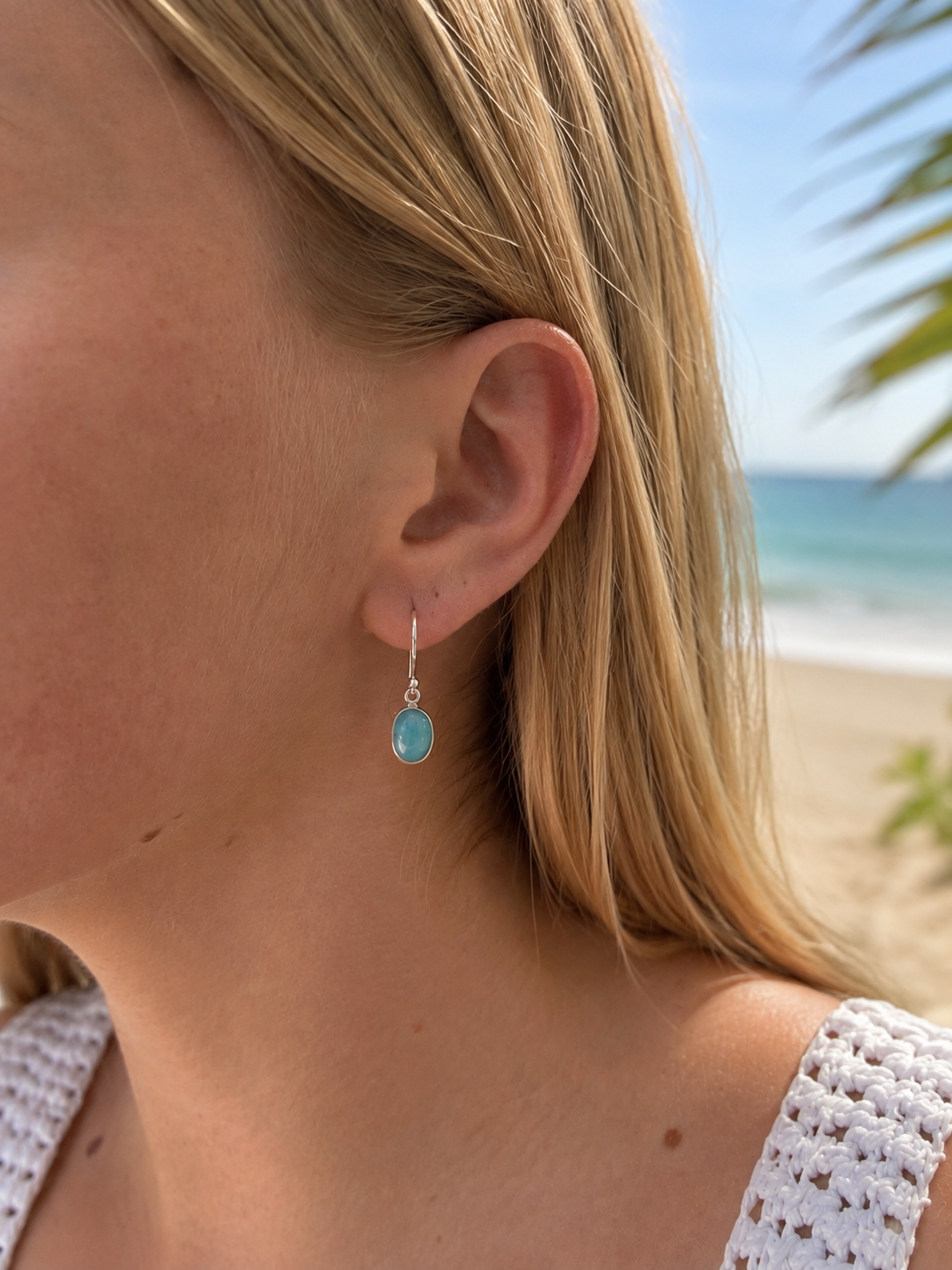 Dreamwave Oval Larimar Hook Earring in sterling silver, worn on model with a soft coastal beach backdrop.
