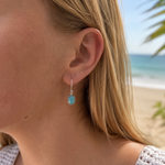 Dreamwave Oval Larimar Hook Earring in sterling silver, worn on model with a soft coastal beach backdrop.