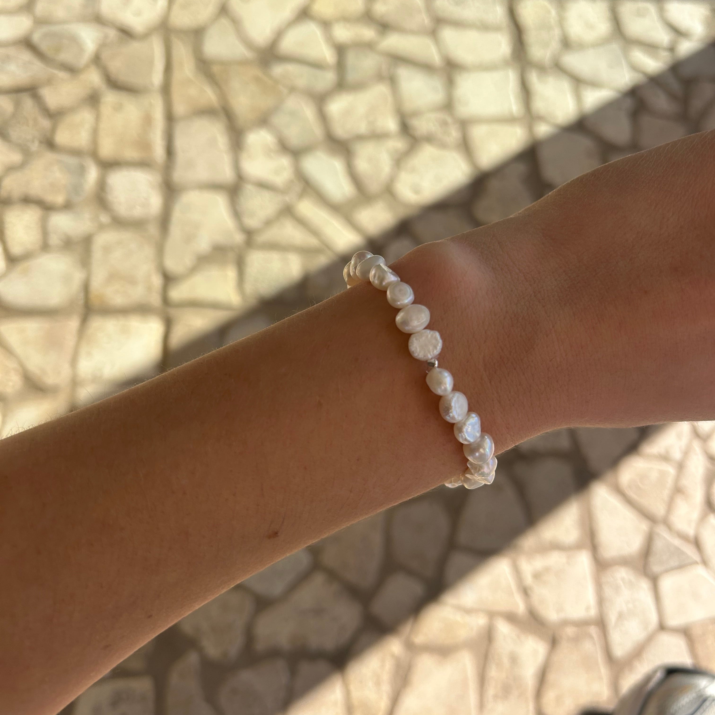 Girls white freshwater pearl stretch bracelet featuring organic white pearls on a clear elastic cord, handcrafted in Australia with a natural coastal style.
