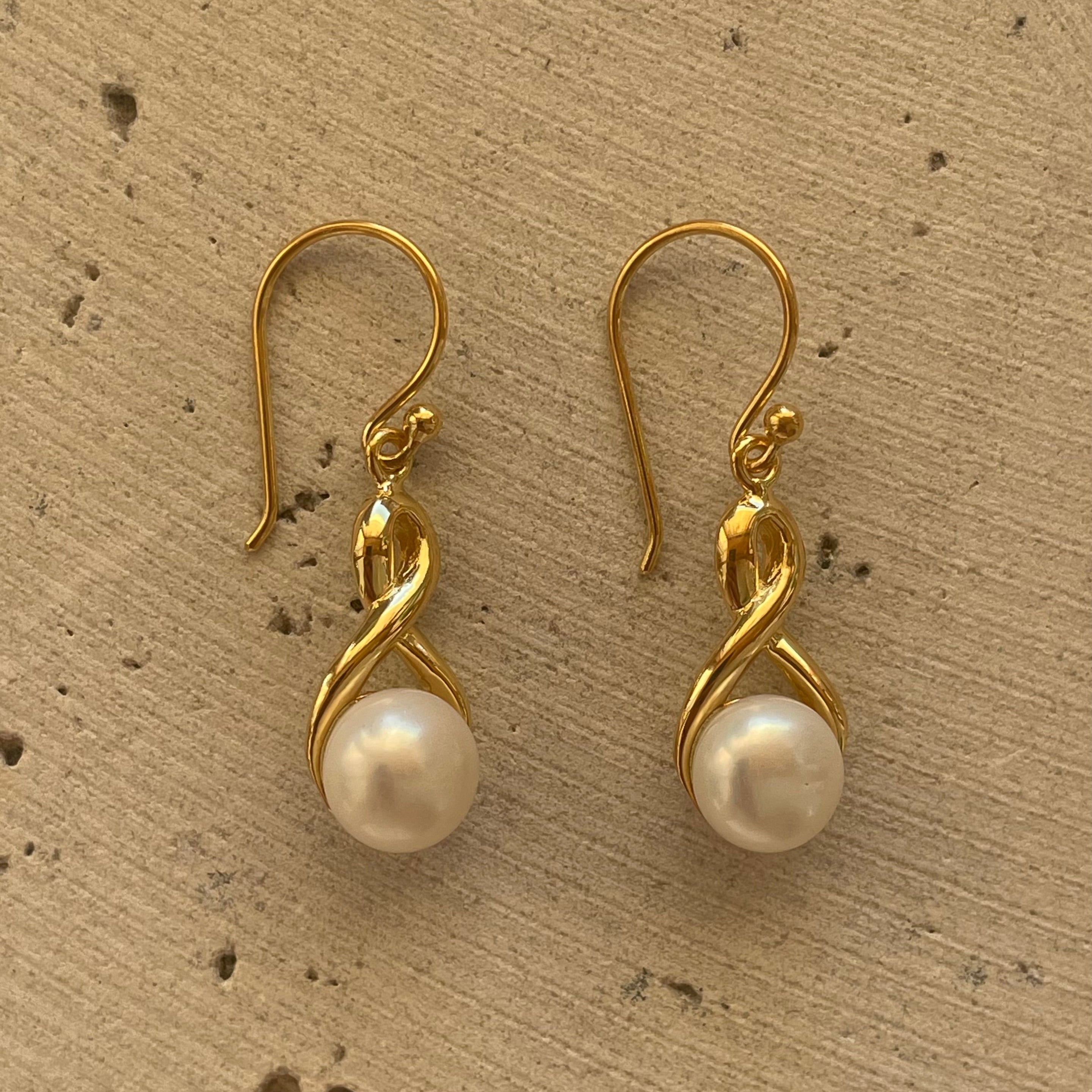 Infinity Pearl Hook Earrings Gold featuring lustrous white pearls and an elegant infinity design with delicate gold hooks.