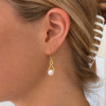 Infinity Pearl Hook Earrings Gold featuring lustrous white pearls and an elegant infinity design with delicate gold hooks.