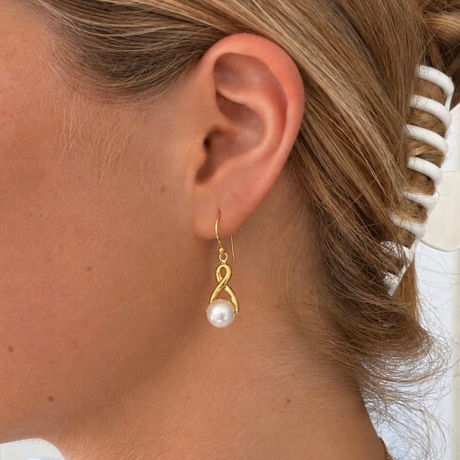Infinity Pearl Hook Earrings Gold featuring lustrous white pearls and an elegant infinity design with delicate gold hooks.