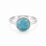 A silver ring with a round, polished light blue larimar stone in a bezel setting