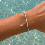 Light blue gemstone and freshwater pearl bracelet featuring delicate white pearls, soft blue beads and sterling silver accents on an adjustable design. A beach-inspired bracelet handcrafted for effortless coastal style.