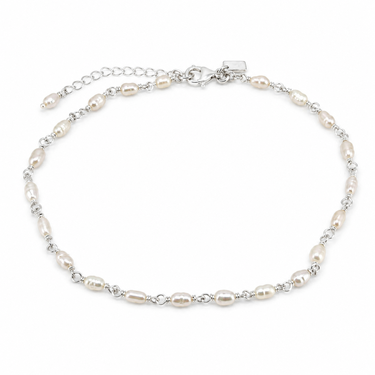 A silver chain anklet featuring irregular white freshwater pearls spaced along the chain, with a lobster clasp and extender chain