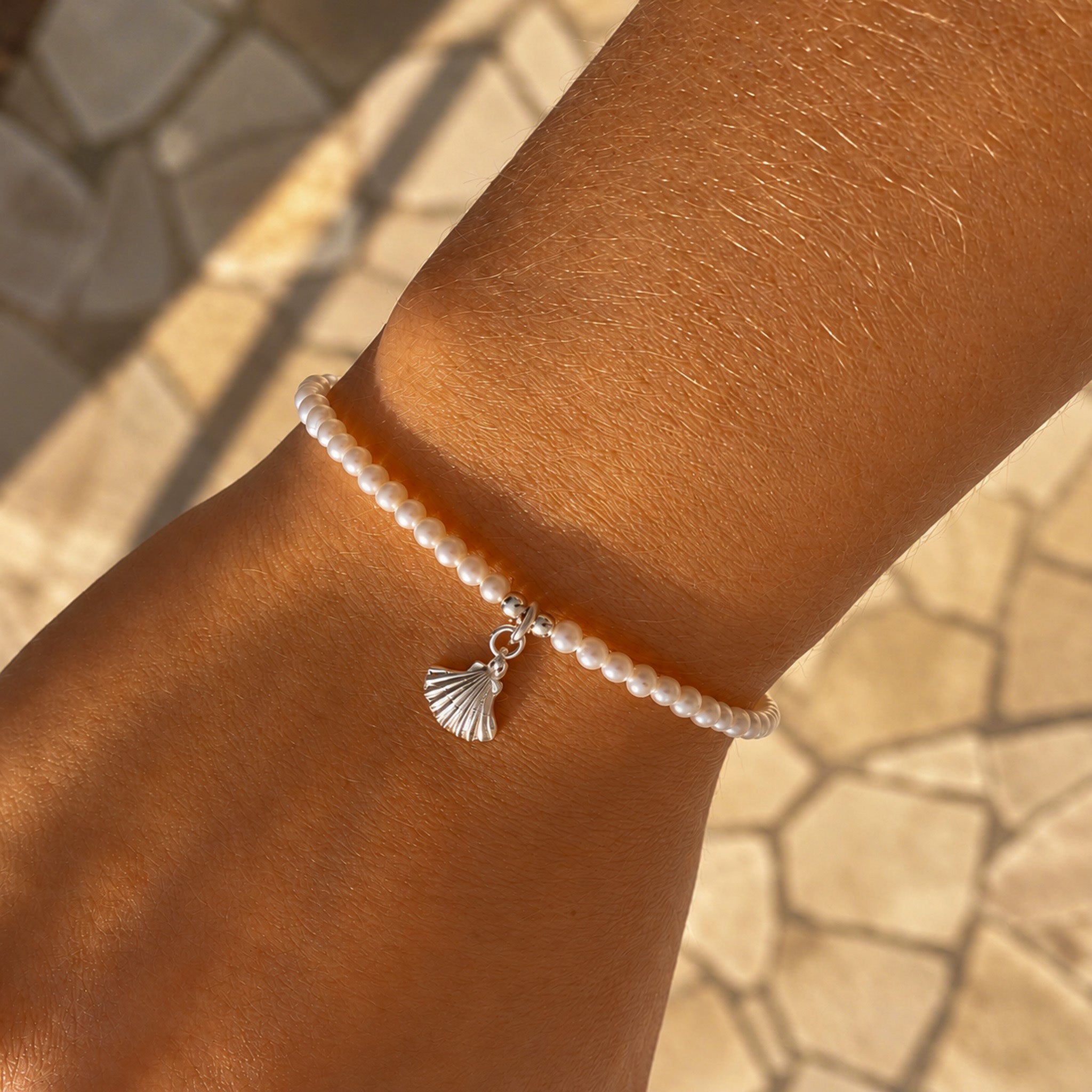 dainty seed pearl bracelet with silver shell charm