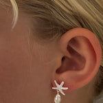 Silver starfish stud earrings featuring a freshwater pearl attached 