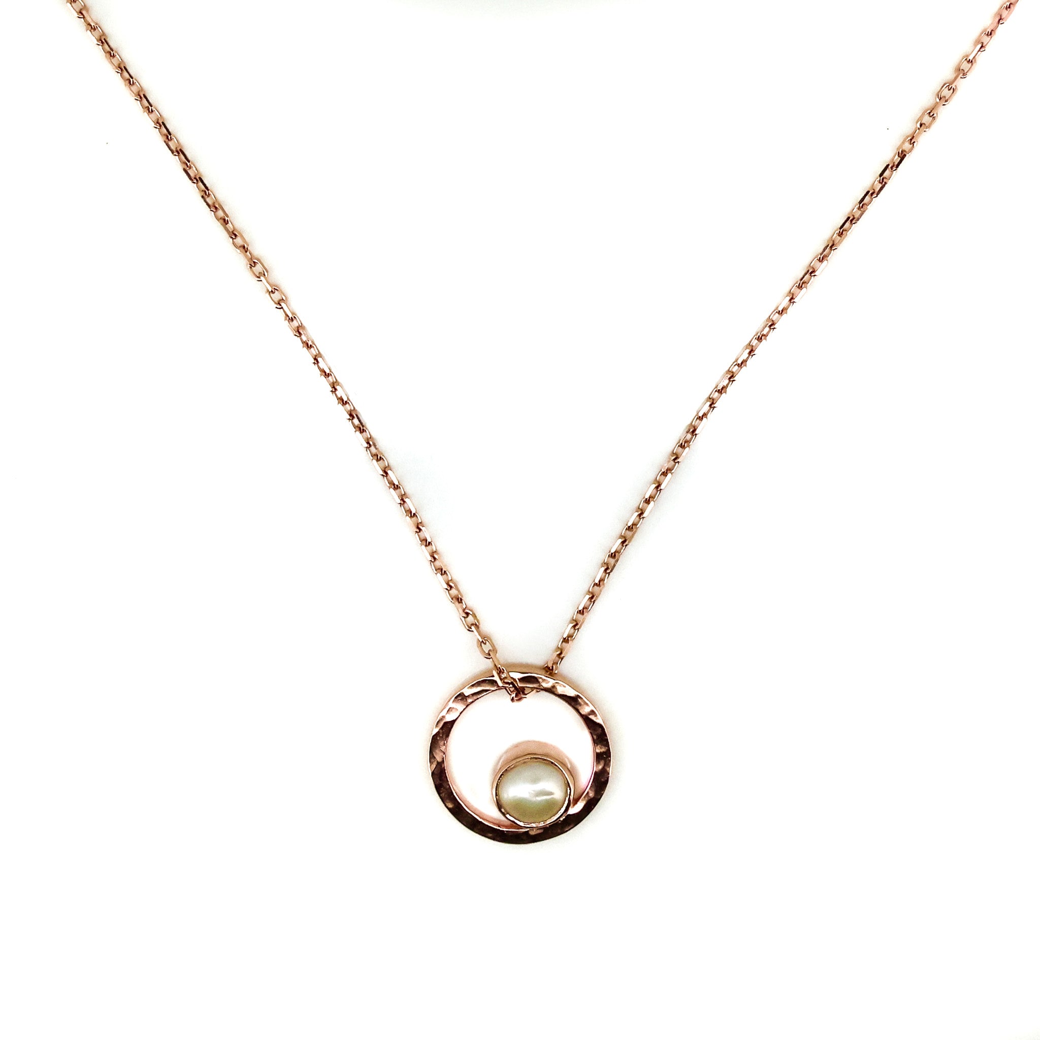 A rose gold necklace with a single pearl pendant, featuring a loop of rose gold at the top which appears to be the setting for the pearl.
