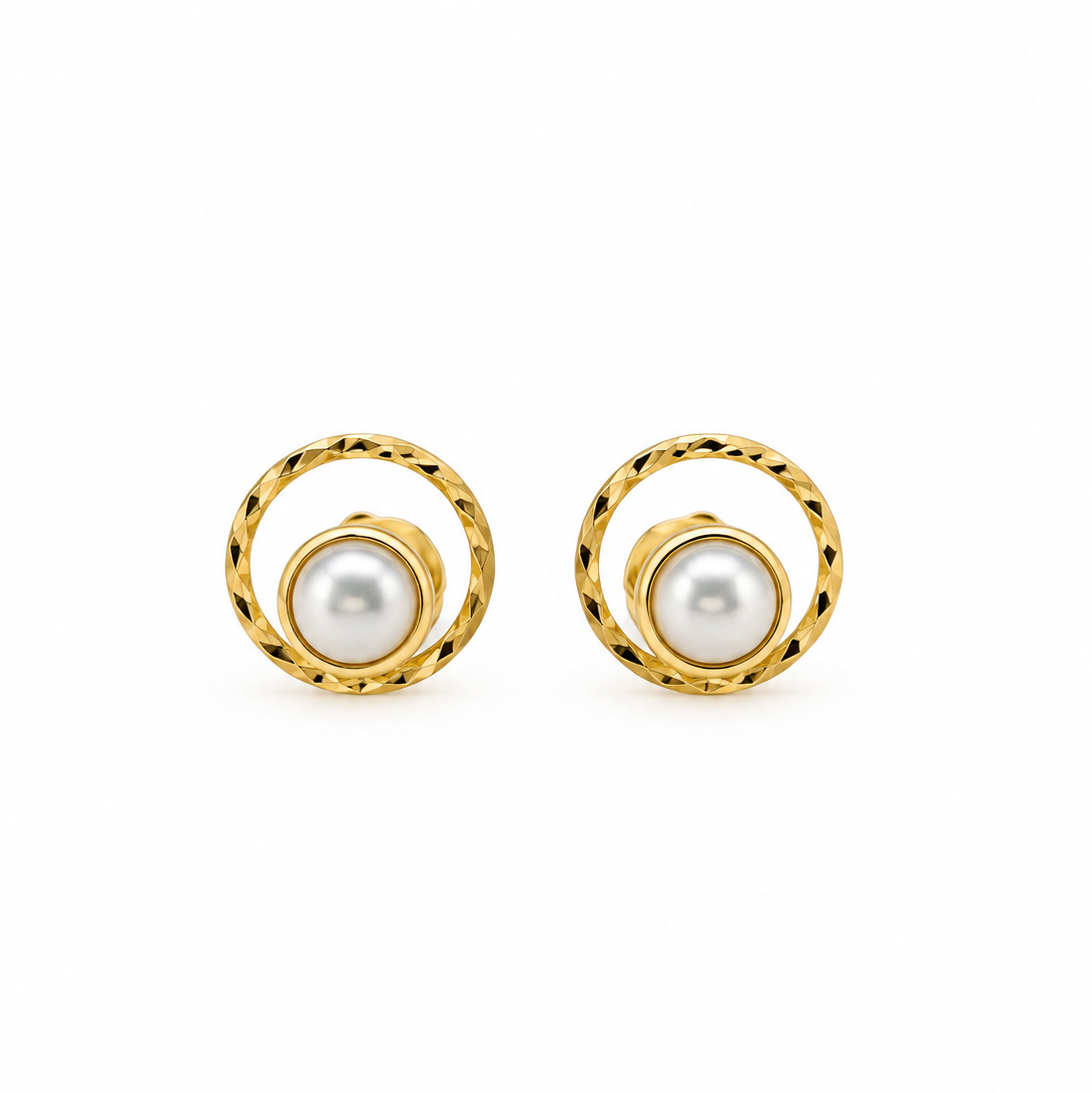 A pair of gold and pearl stud earrings with a textured circular gold frame and a central white pearl, shown on a plain white background.