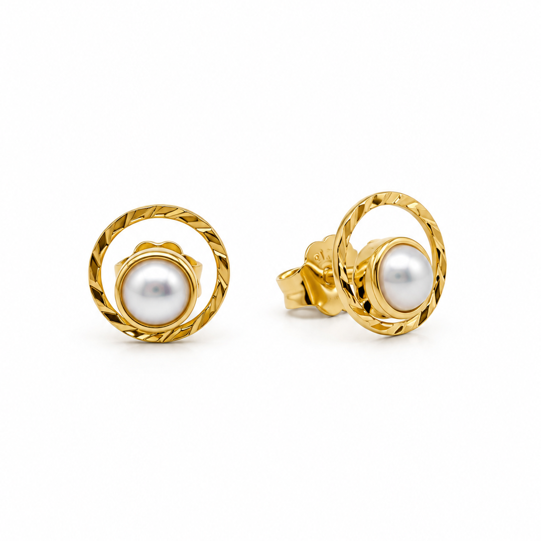 A pair of gold and pearl stud earrings on a clean white background. One earring is shown from the front, displaying a round white pearl nestled within a textured, twisted gold ring, while the other is shown from the side/back, displaying the post and clasp mechanism.