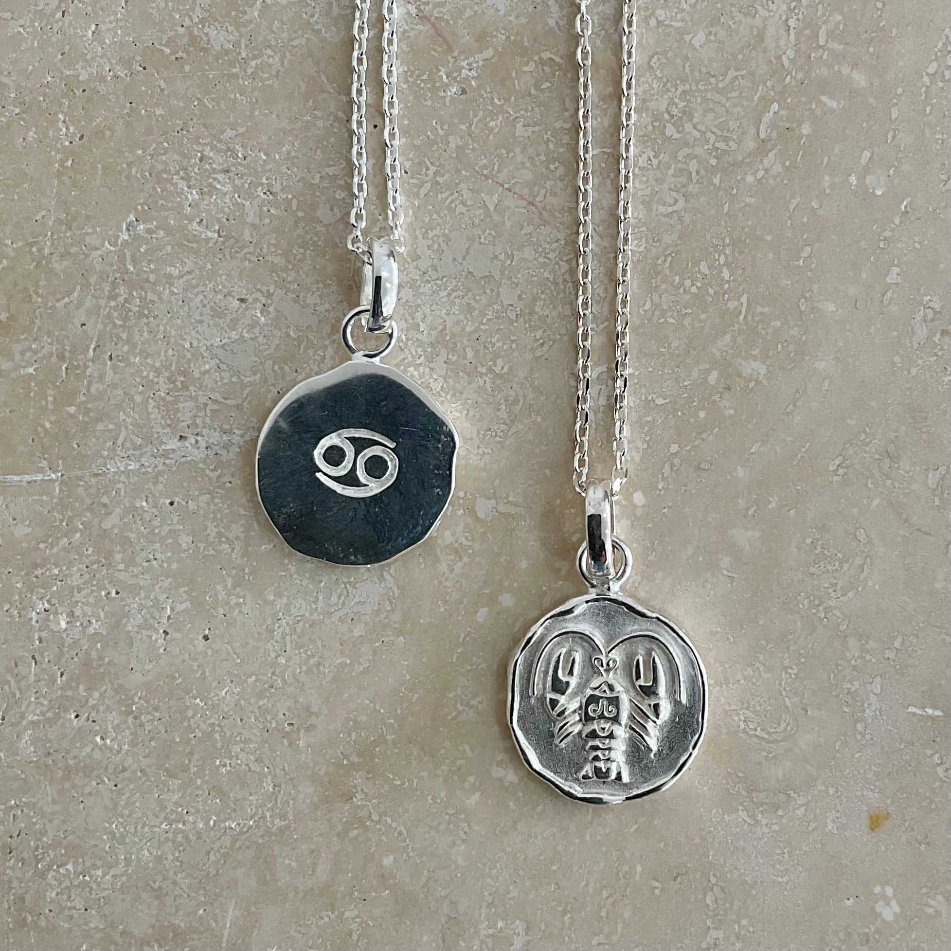 sterling silver necklaces with zodiac sign pendant, double sided one showcasing the Cancer symbol and the other with a dainty chain design, both on sterling silver pendant