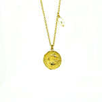 A gold necklace featuring a Pisces zodiac symbol and a pearl charm on a chain.
