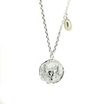 A silver necklace featuring a Taurus bull pendant with a lustrous pearl attached to the top.