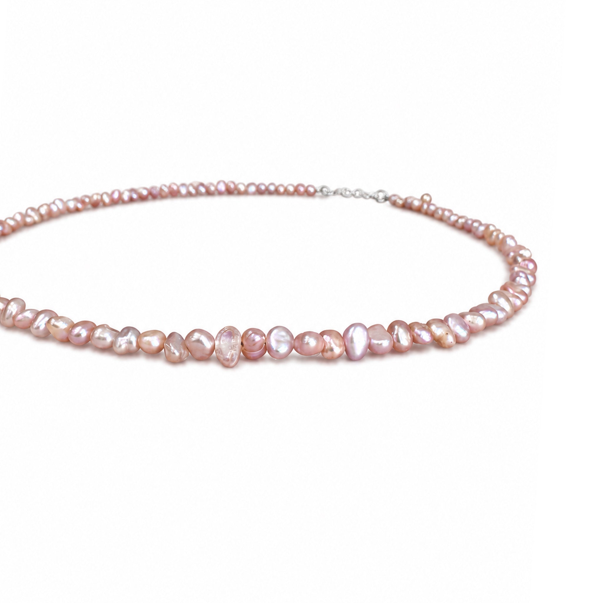 Close-up of natural blush pink freshwater pearls showing individual shape and lustre