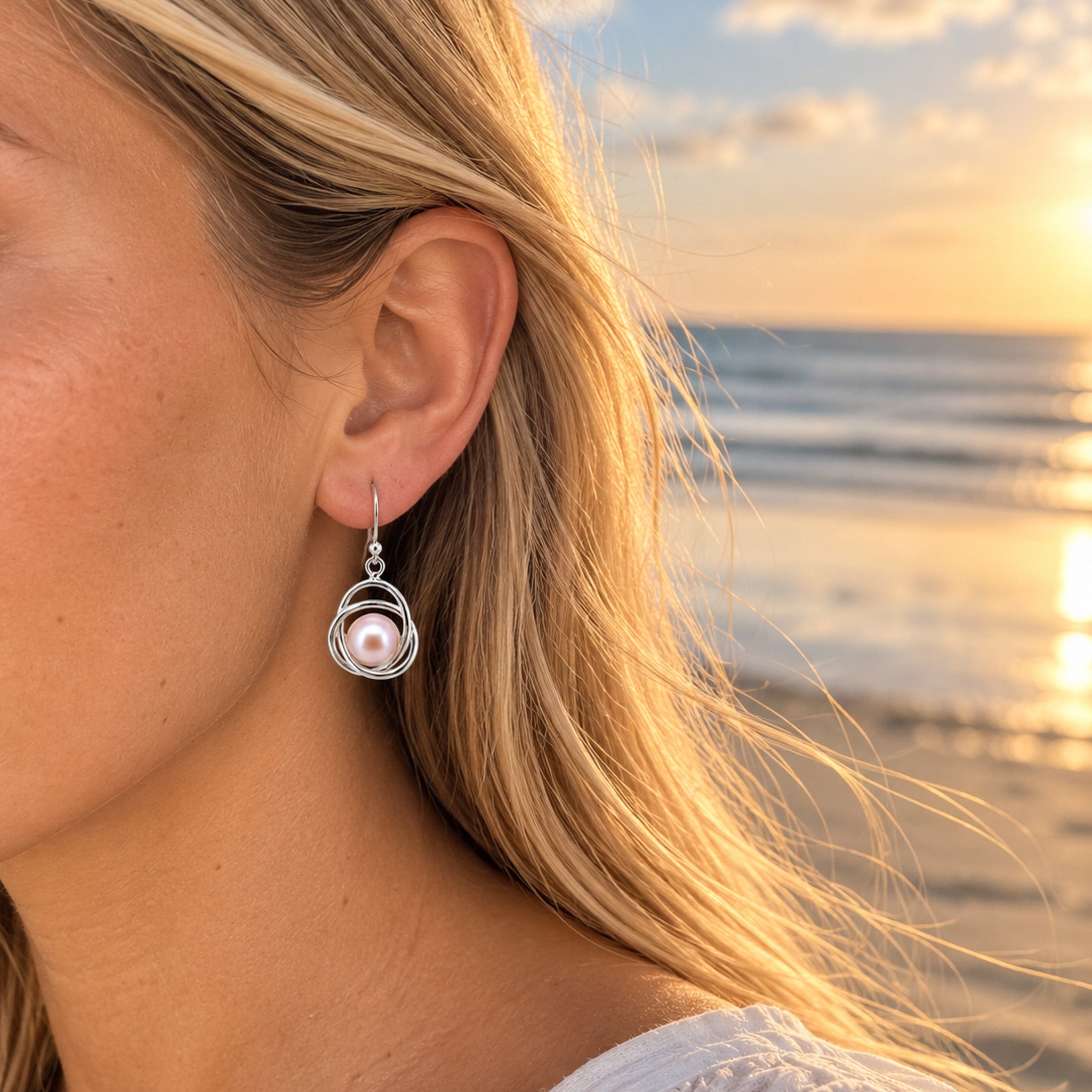 Woman wearing Cable Beach Haze pink freshwater pearl earrings in sterling silver