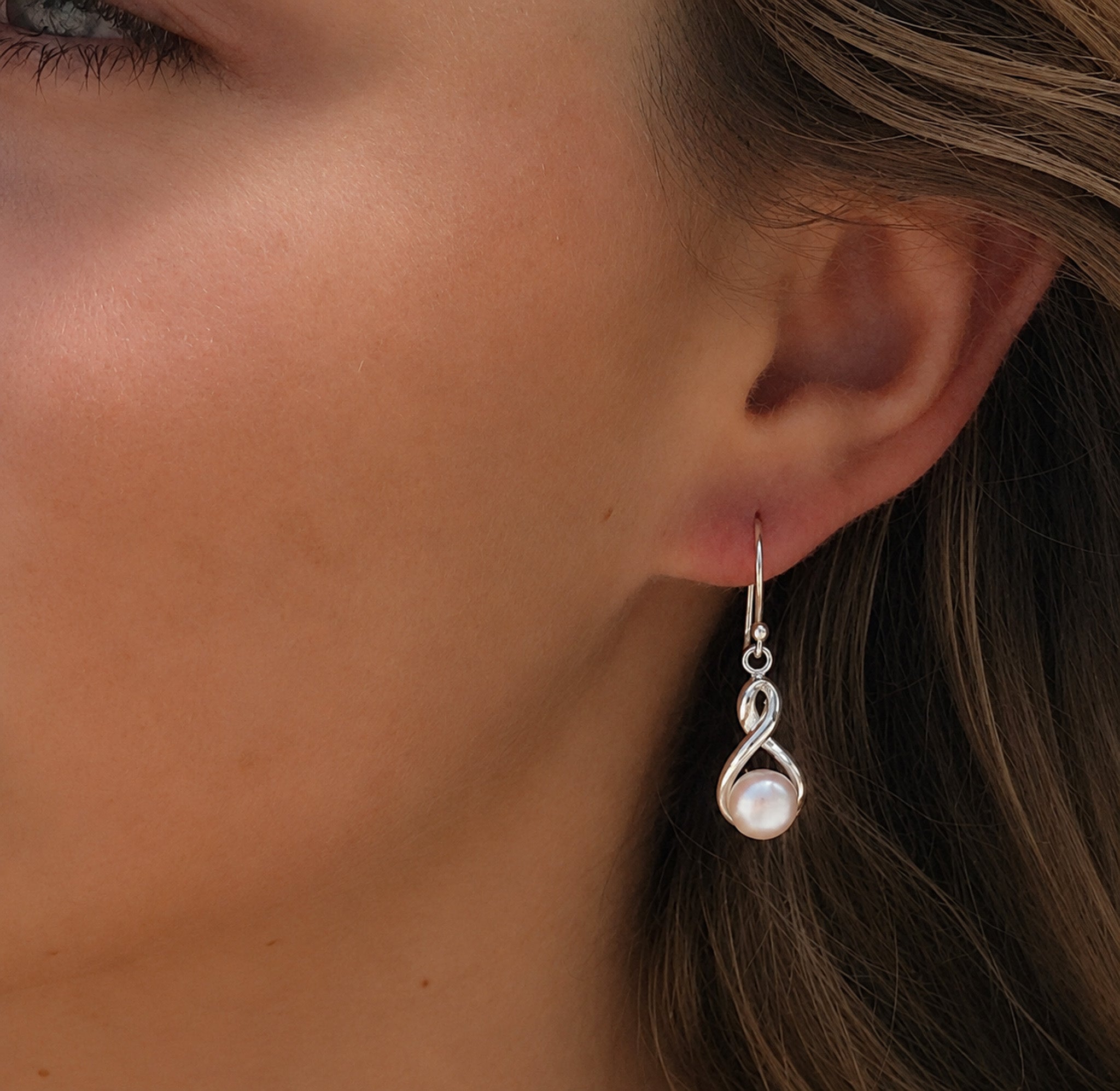 sterling silver earrings in a swirl design with a freshwater pearl