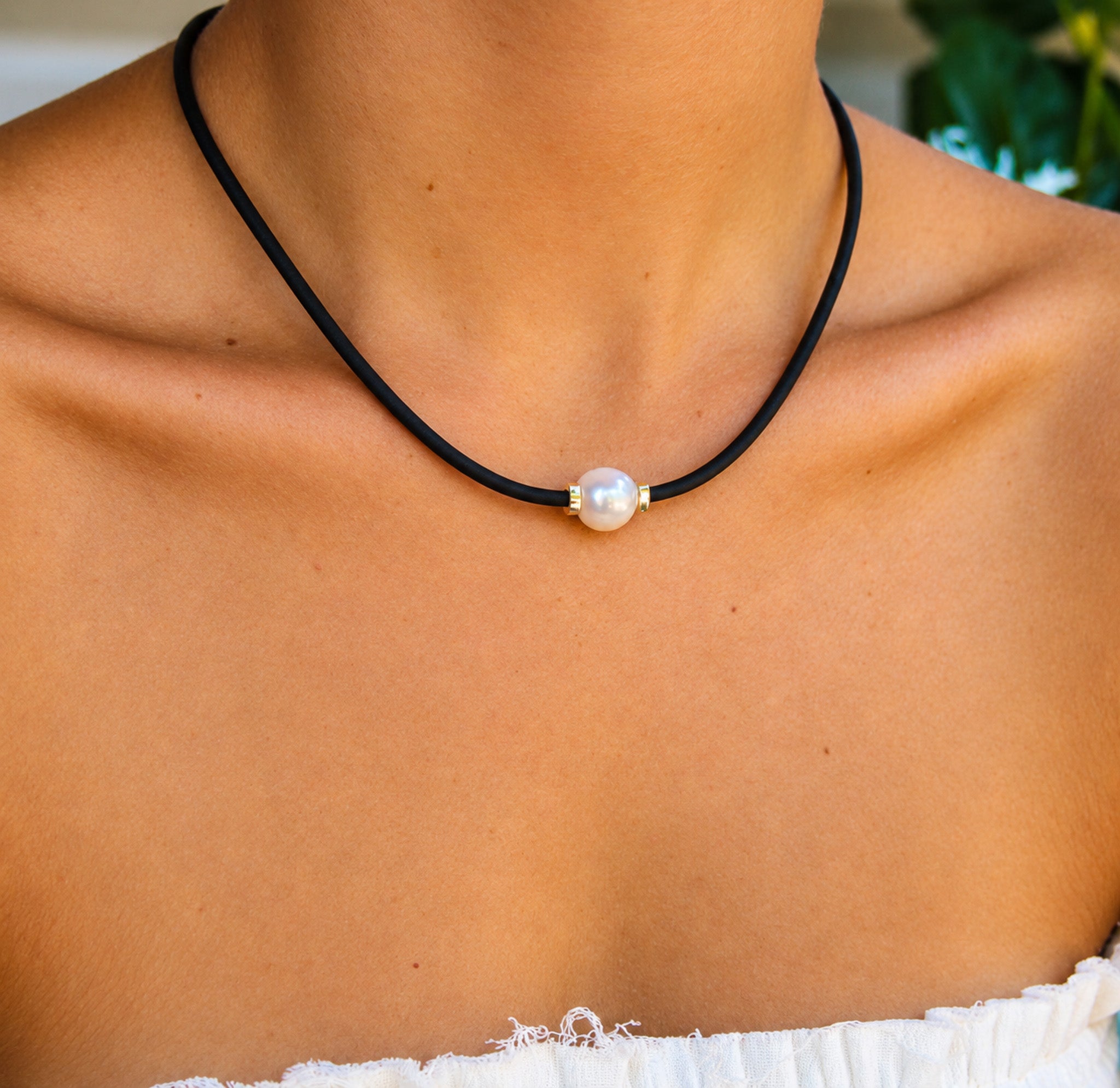 large pearl on a black neoprene rubber necklace
