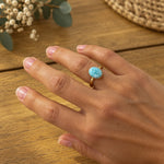 Woman wearing gold oval larimar ring Australia