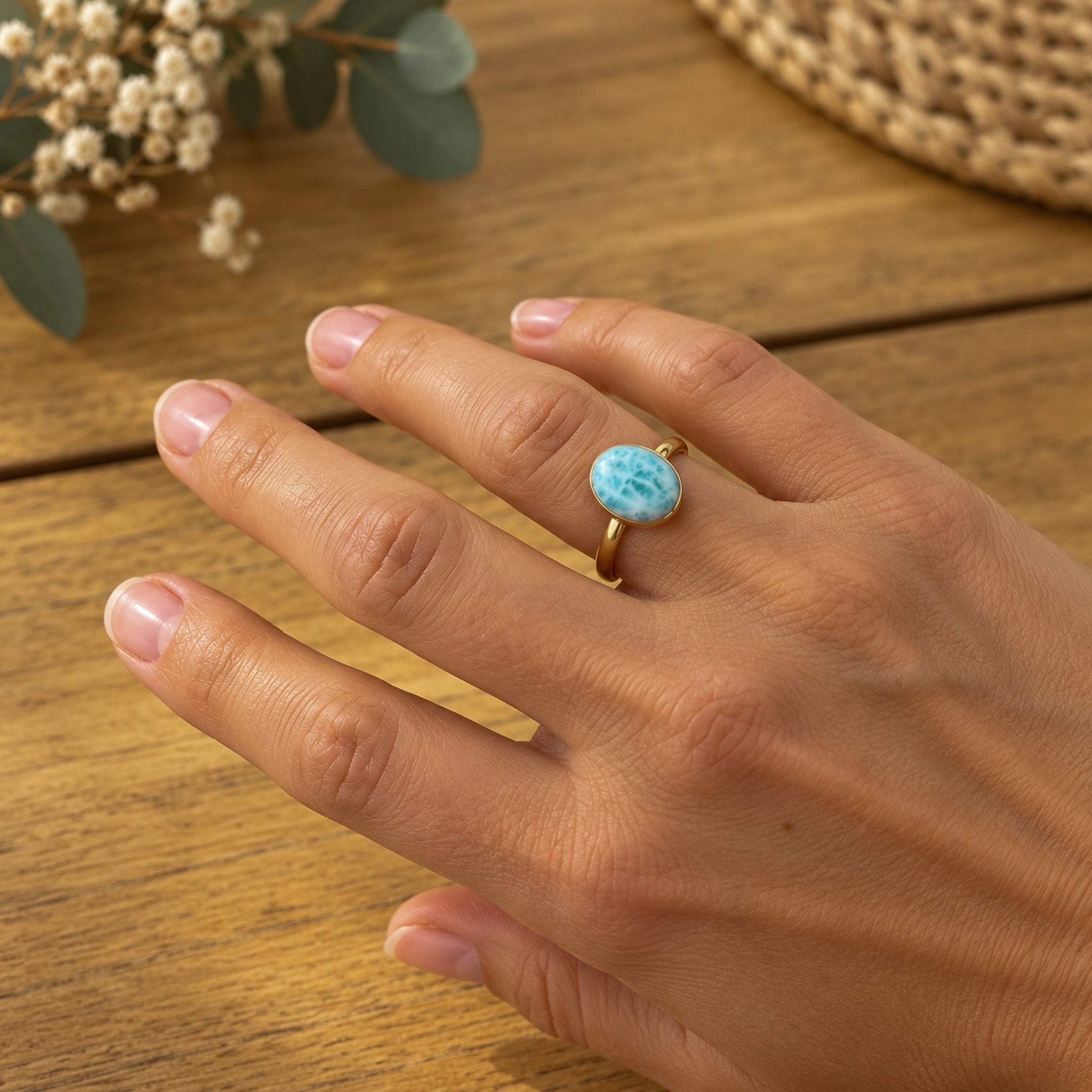 Woman wearing gold oval larimar ring Australia