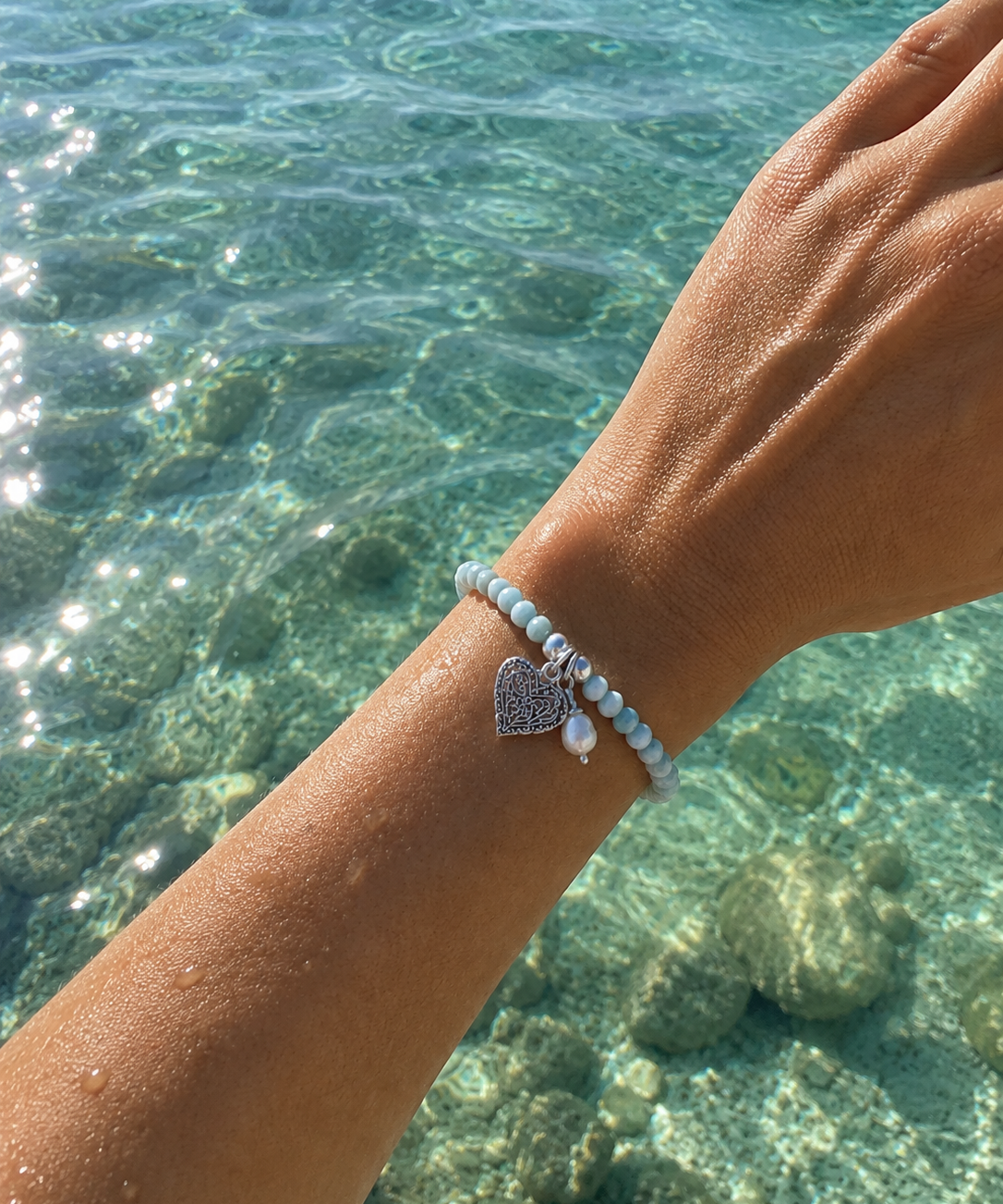 Ocean Hearts Larimar Stretch Bracelet featuring genuine Larimar gemstones, freshwater pearl charm and sterling silver heart charm.