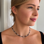 Model styling the Summer Sun Pearl Necklace Black by Lush Designs Jewellery, a delicate freshwater pearl and black cotton necklace with a relaxed bohemian coastal look.