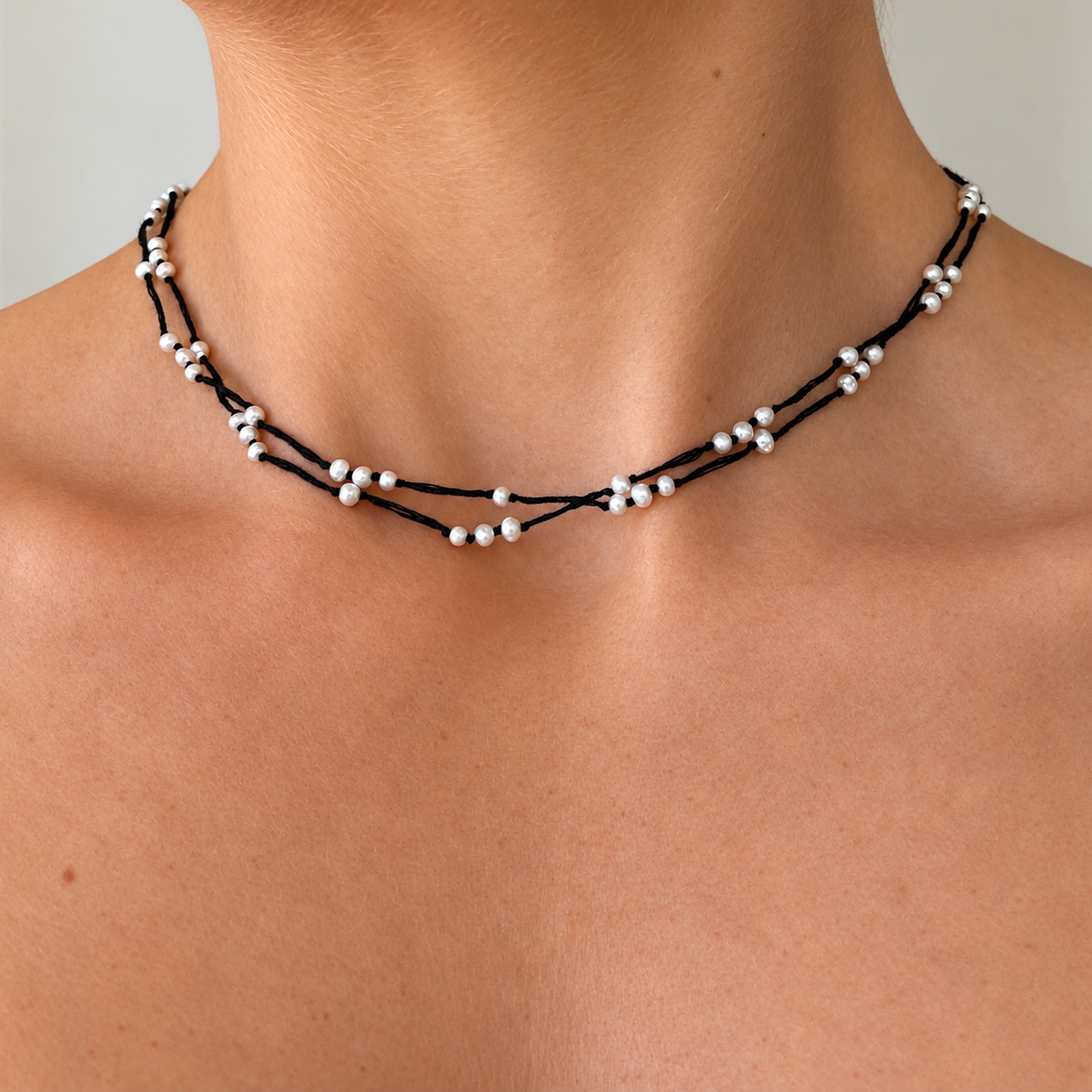 Close-up of model wearing the Summer Sun Pearl Necklace Black, featuring delicate 3mm freshwater rice pearls on layered black cotton strands, made in Broome Western Australia.