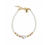 A handcrafted bracelet with white beads, pink opal stones, and gold accents, featuring a gold clasp.