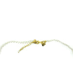 Close-up small pearl necklace with Lush Designs tag and adjustable clasp