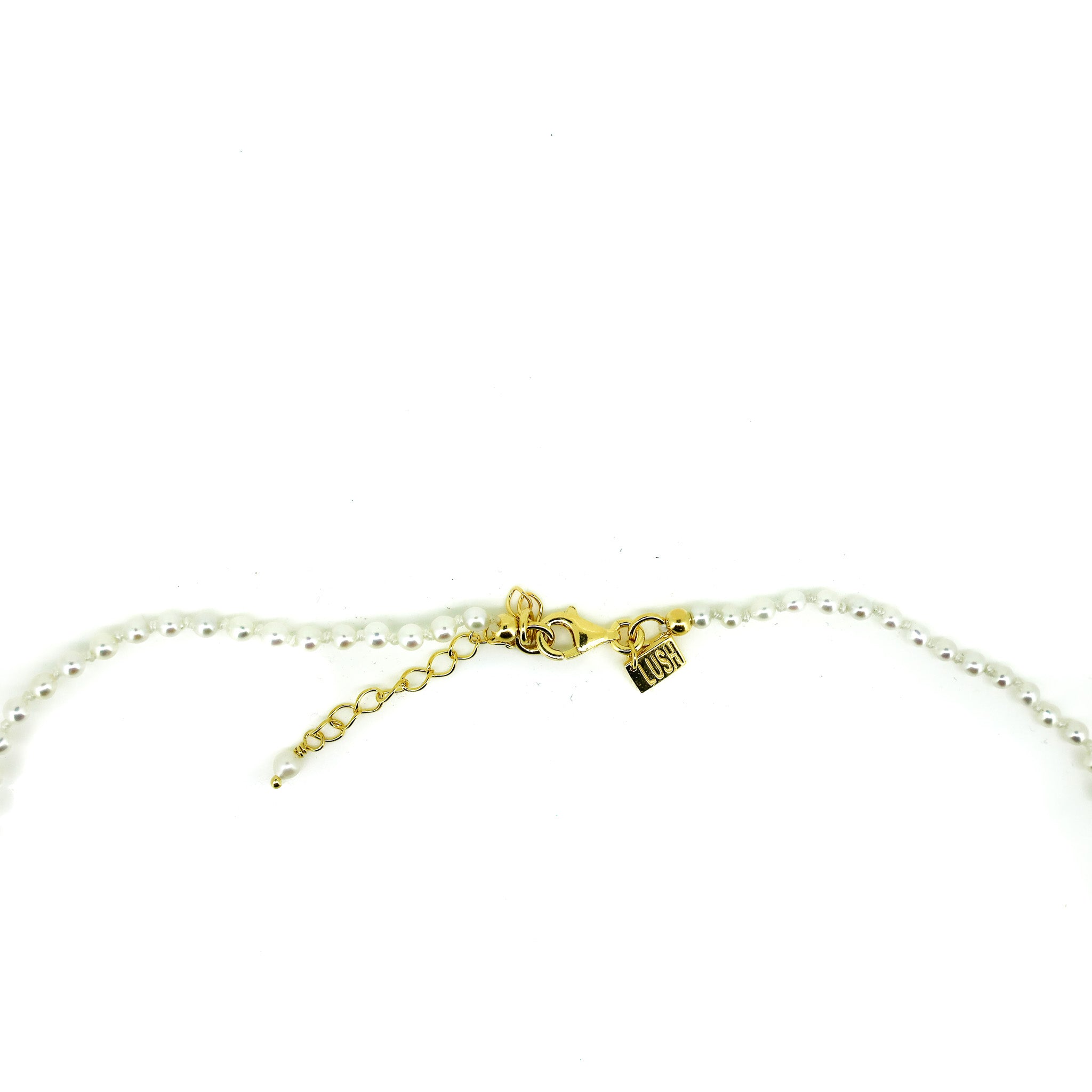 Close-up small pearl necklace with Lush Designs tag and adjustable clasp