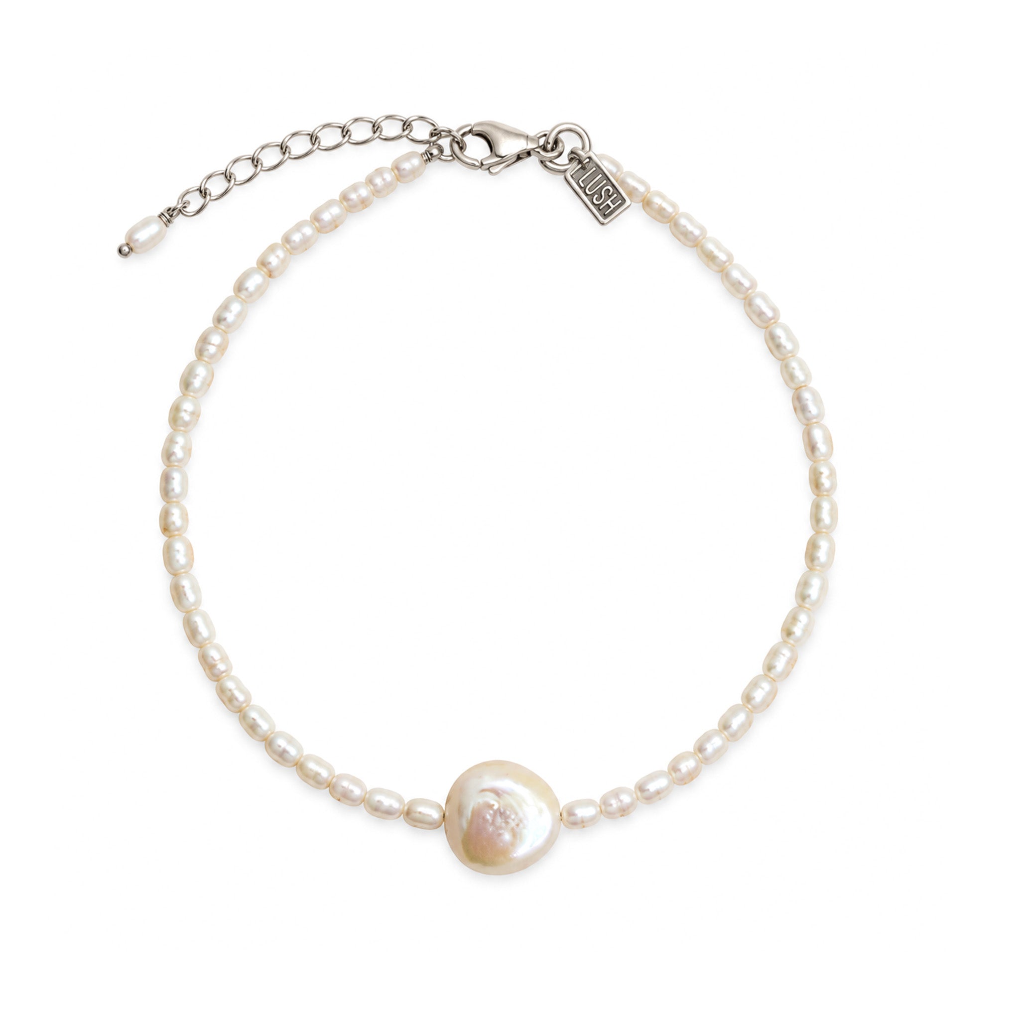 A delicate pearl bracelet with a central Keshi pearl and a silver chain extender clasp.