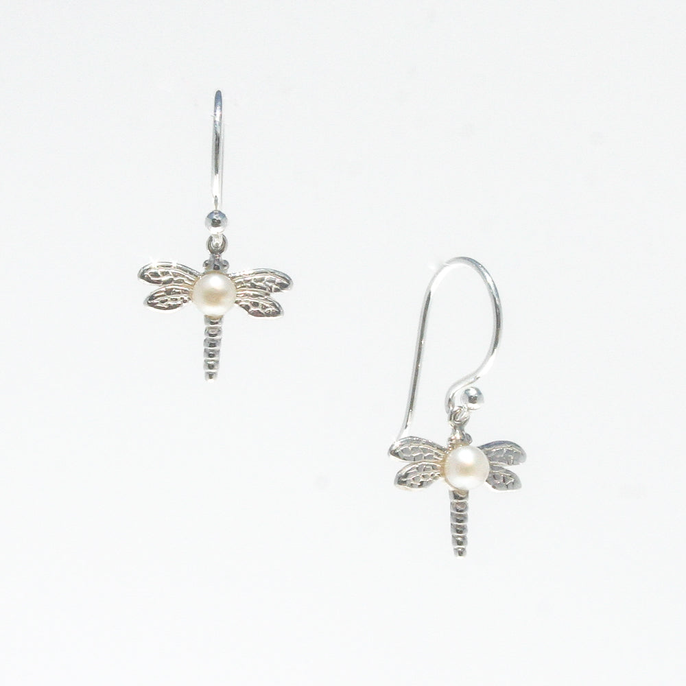 A pair of sterling silver hook earrings featuring a detailed dragonfly design with a freshwater pearl positioned at the center of the dragonfly's body.