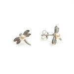 A pair of sterling silver dragonfly stud earrings with a freshwater pearl positioned in the center of each dragonfly's body.
