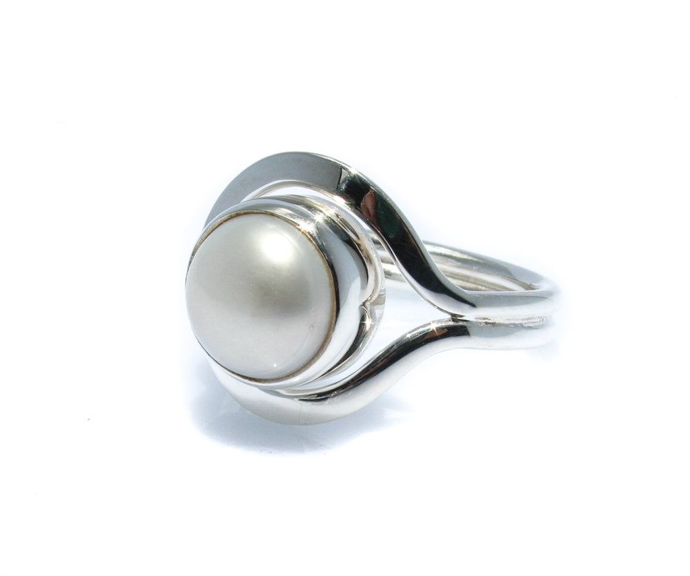 A white freshwater pearl ring set in a silver bezel, with a design reminiscent of a Cable Beach Sunset.