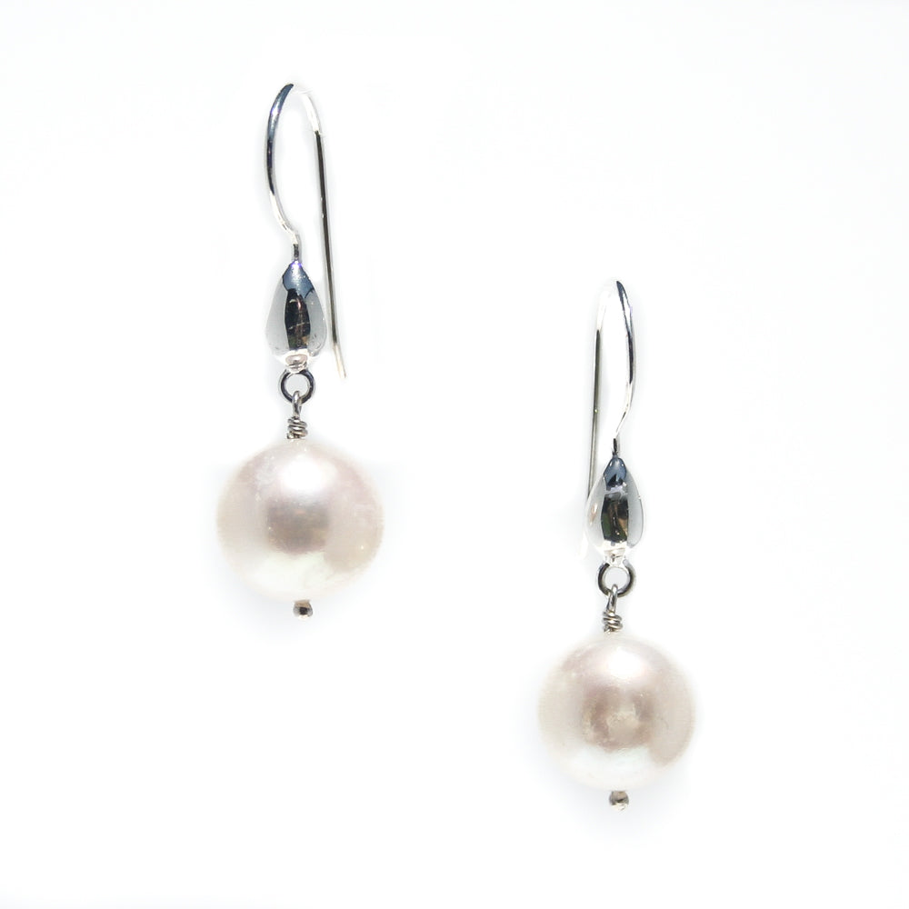 A pair of pearl tear drop earrings with round pearls on sterling silver shephard hooks.