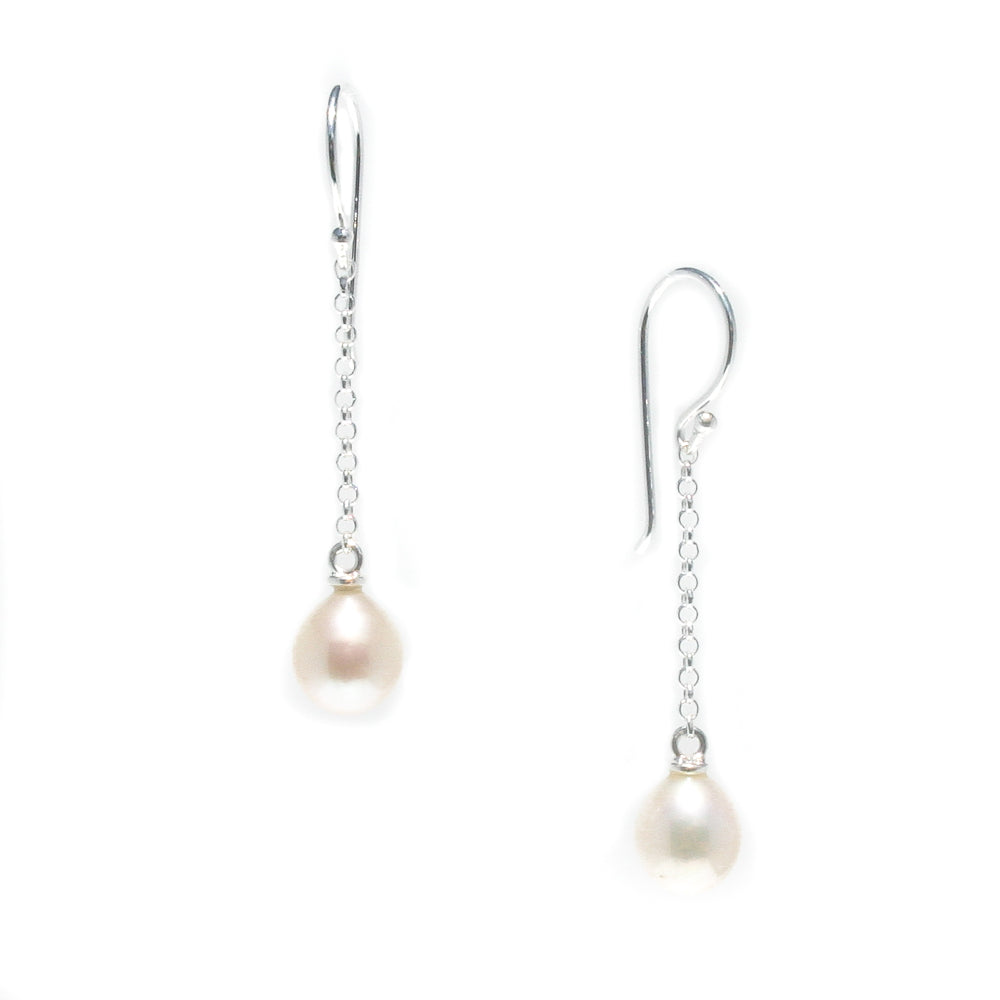 A pair of hook earrings featuring white pearls attached to silver chains.
