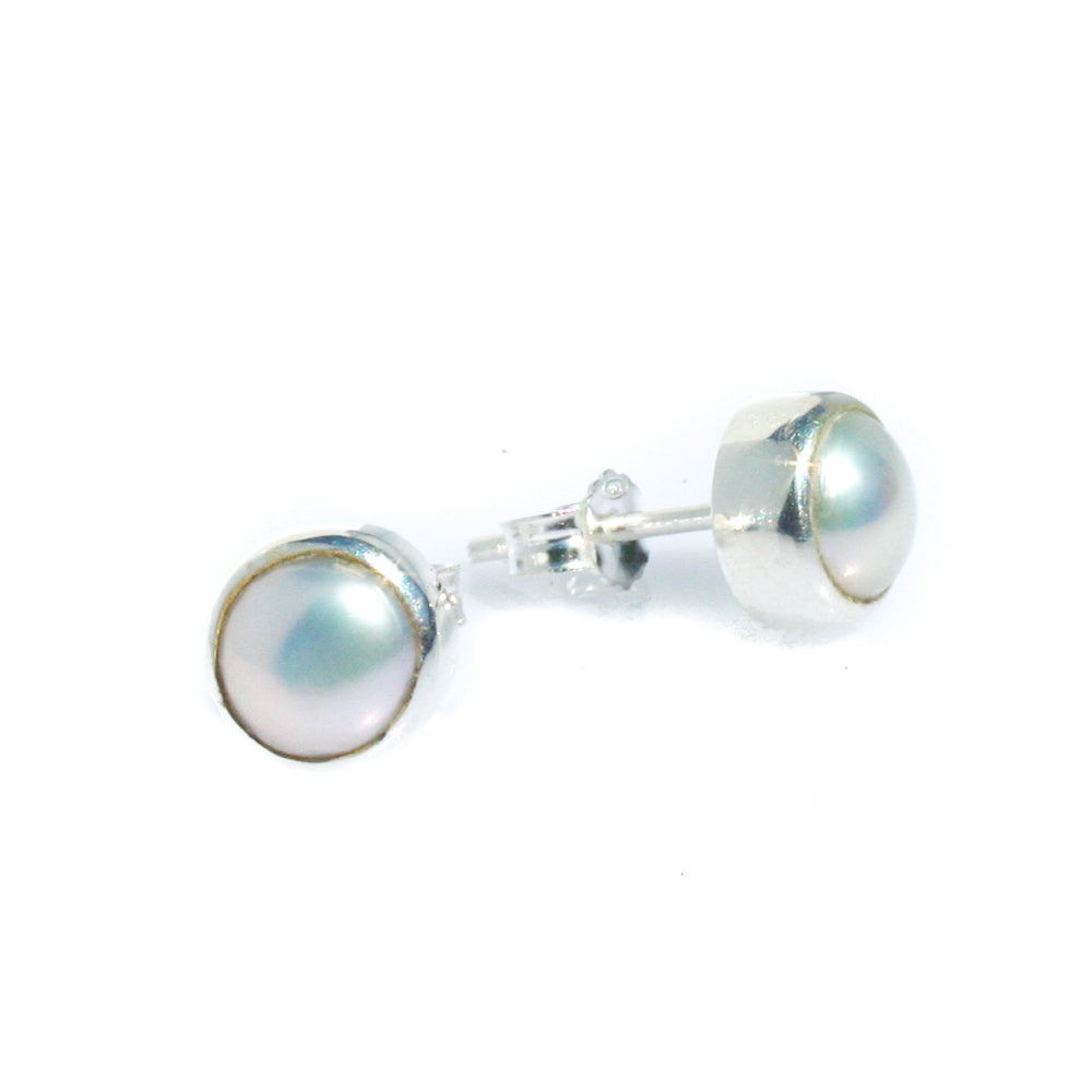 A pair of white pearl stud earrings bezel set in sterling silver.