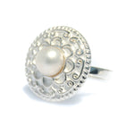 A sterling silver ring with a detailed circular design and a central white freshwater pearl, isolated on a white background.