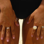 A sterling silver ring with a detailed circular design and a central white freshwater pearl